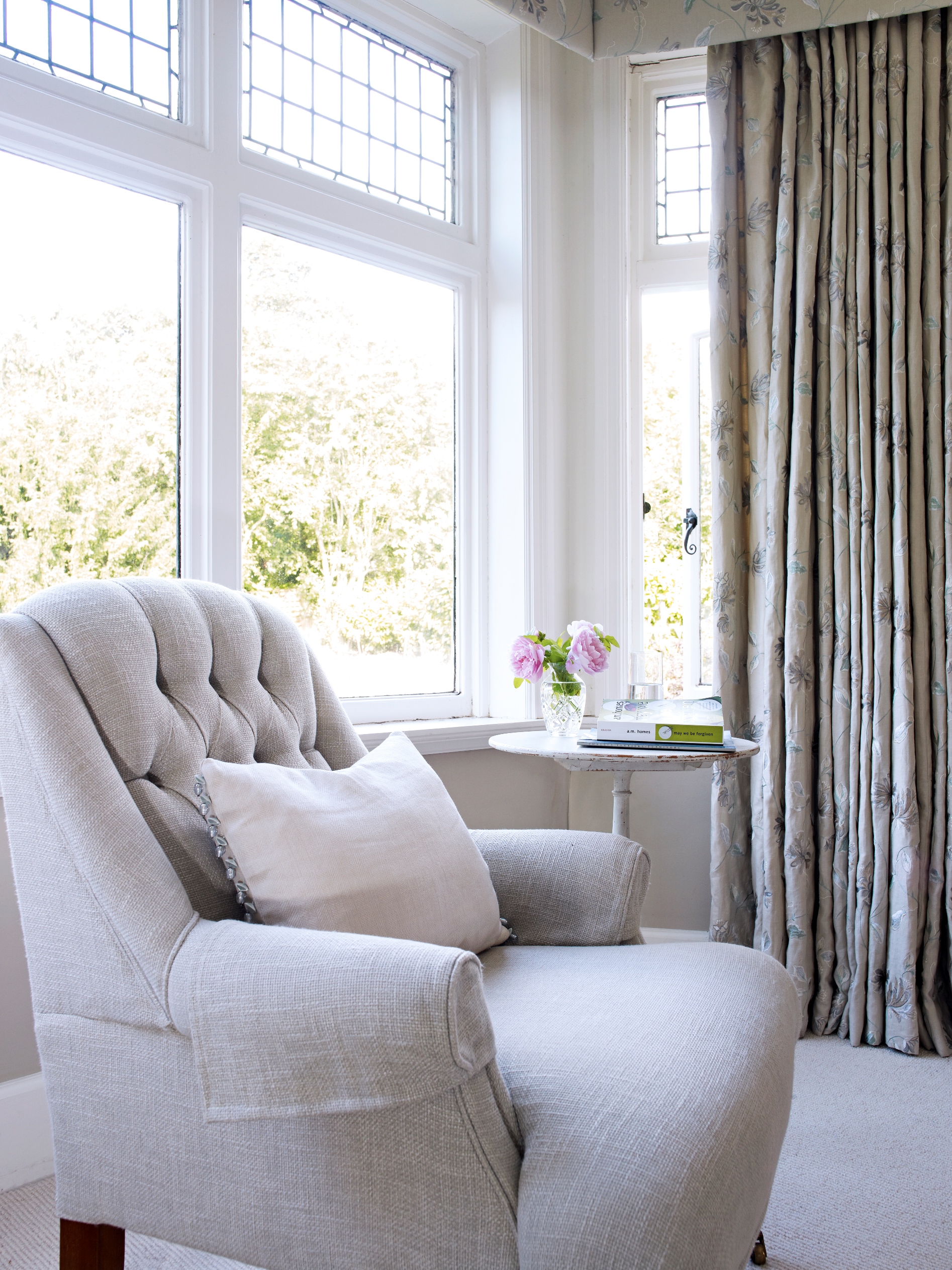 Simple, gently coloured embroidered linen picks up the colours in the original stained glass, the bedroom and the much loved garden beyond 