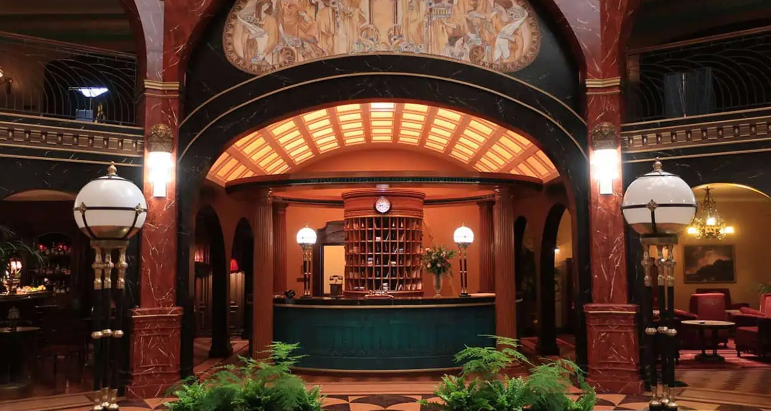 Reception lobby scene featuring the globe floor lamps and crystal column wall lights on the set of A Gentleman in Moscow.