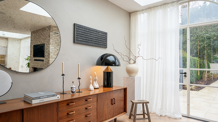 Mid-century inspired interior with VENESTRE luxury sheer curtains, installed on large windows to enhance natural daylight. The bespoke window treatments provide a refined backdrop for designer furniture and curated accessories, showcasing VENESTRE’s commitment to minimal elegance.