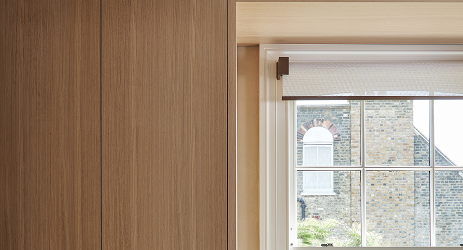 Elegant, bespoke VENESTRE roller installed to the architrave, surrounded with custom cabinetry.