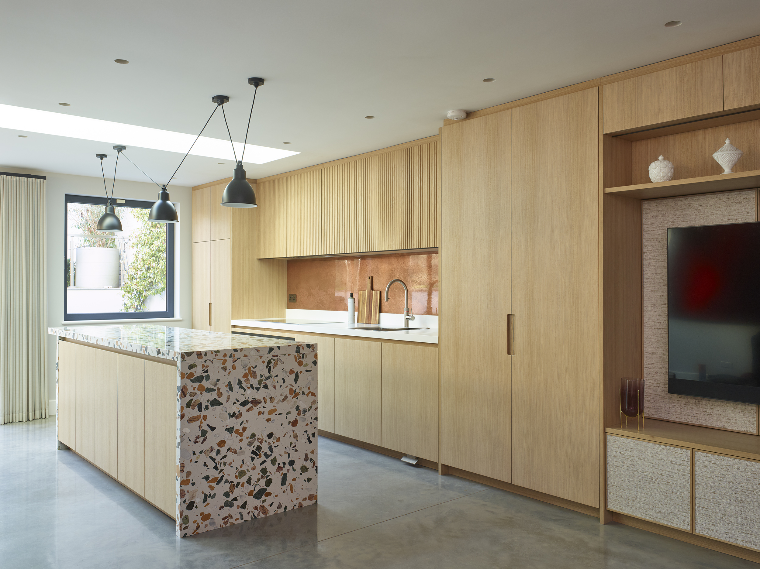 Copper splashback with terrazzo island