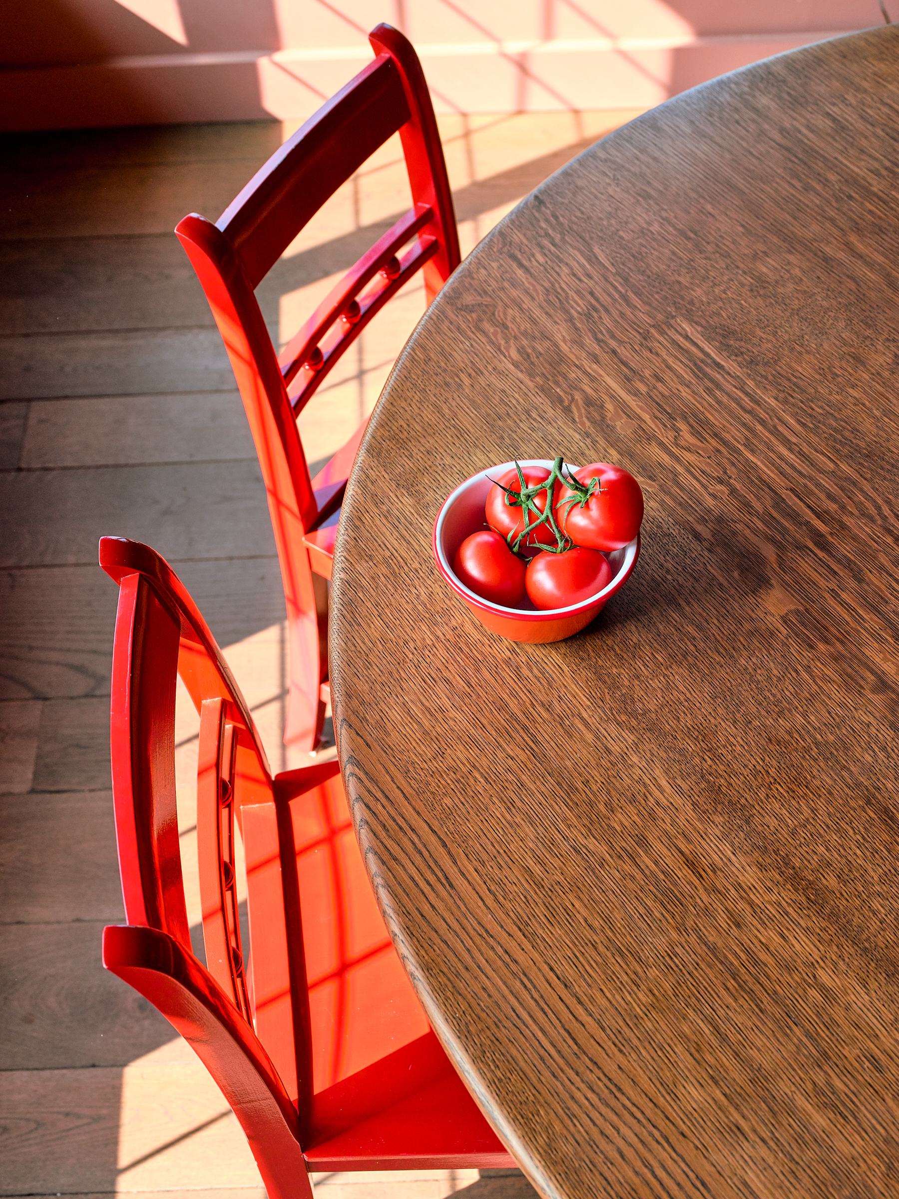 Round oak kitchen table with Plain English Jam red chairs