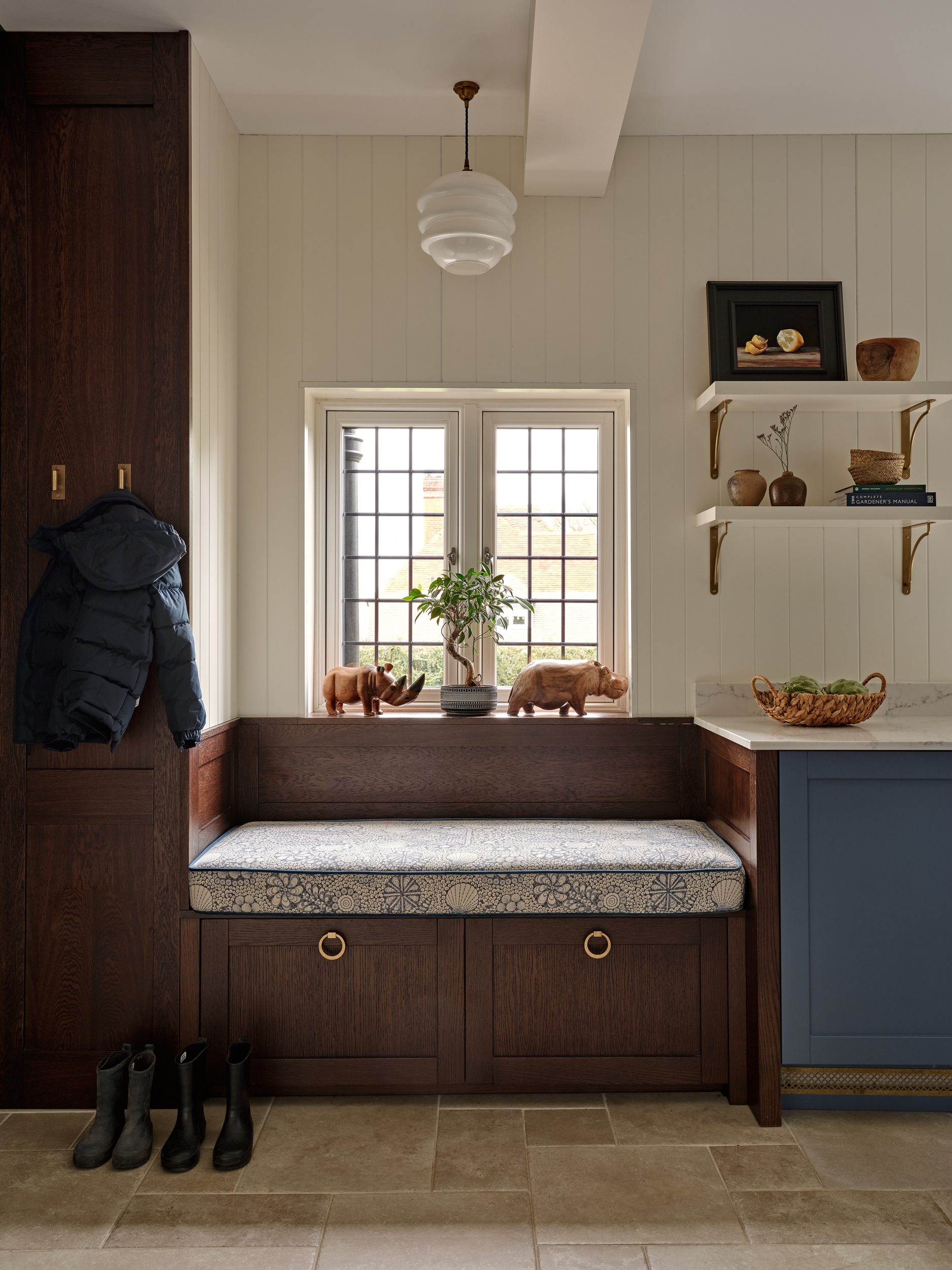 Bespoke joinery in utility room. Stained oak joinery with upholstered window seat. Spray finish on cabinets. 