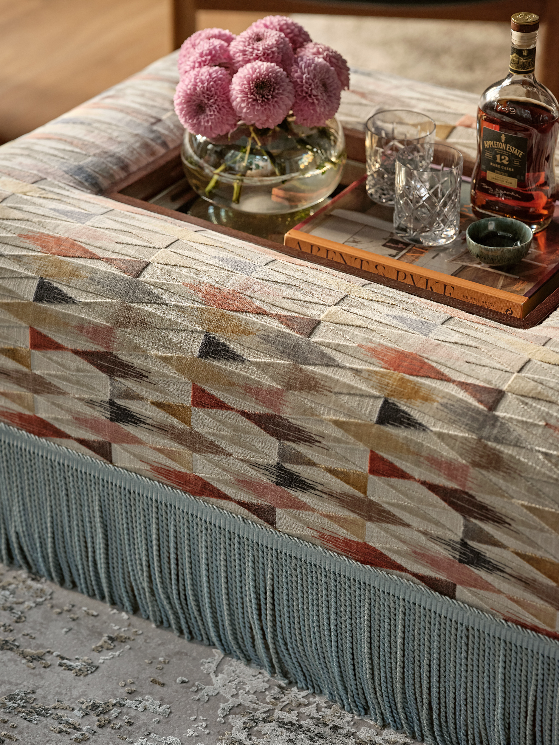 Bespoke, upholstered ottoman with removable stained oak tray. Tray has inset antique mirror.  Fringe detail to base of ottoman.