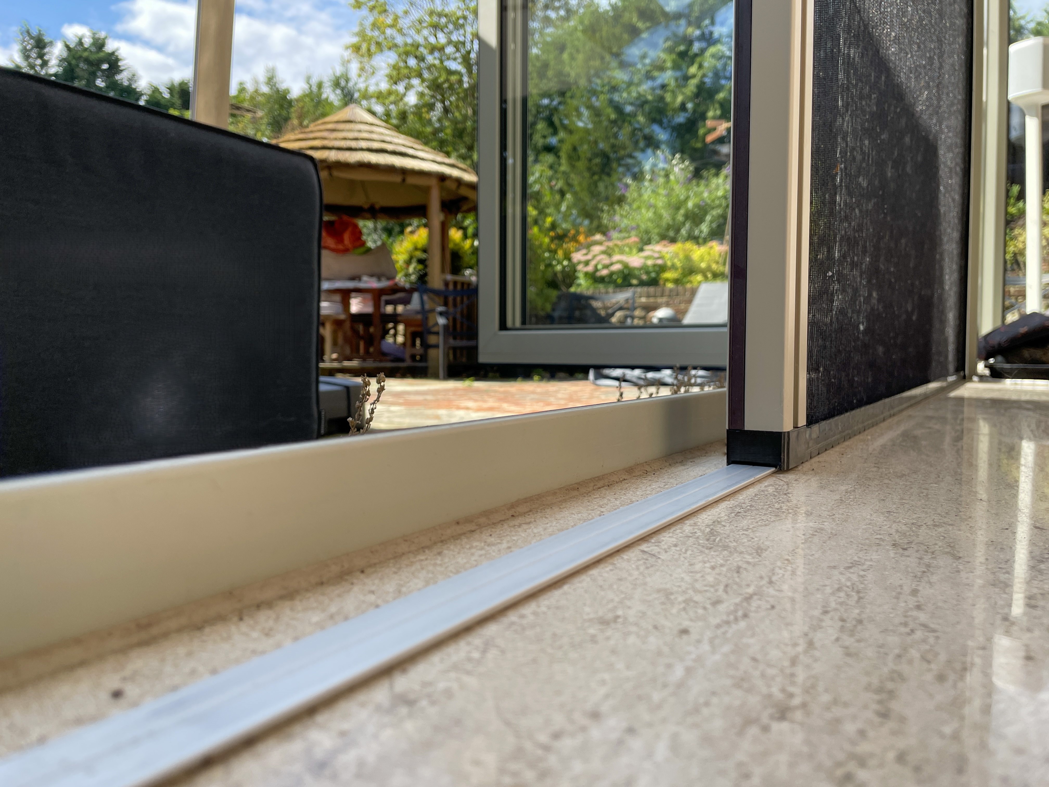 Close up of pleated screen's flush floor rail