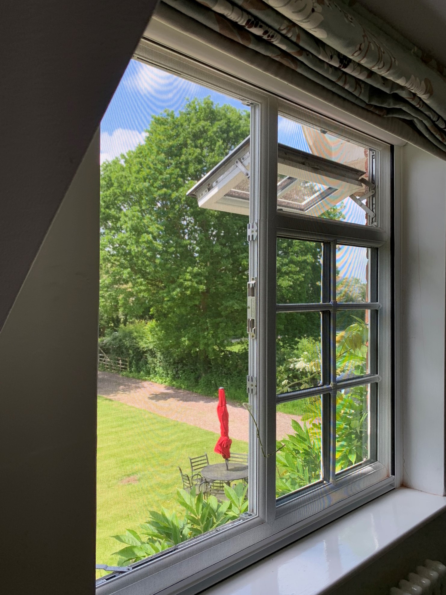 Window open allowing fresh air in whilst a window screen keeps flies out