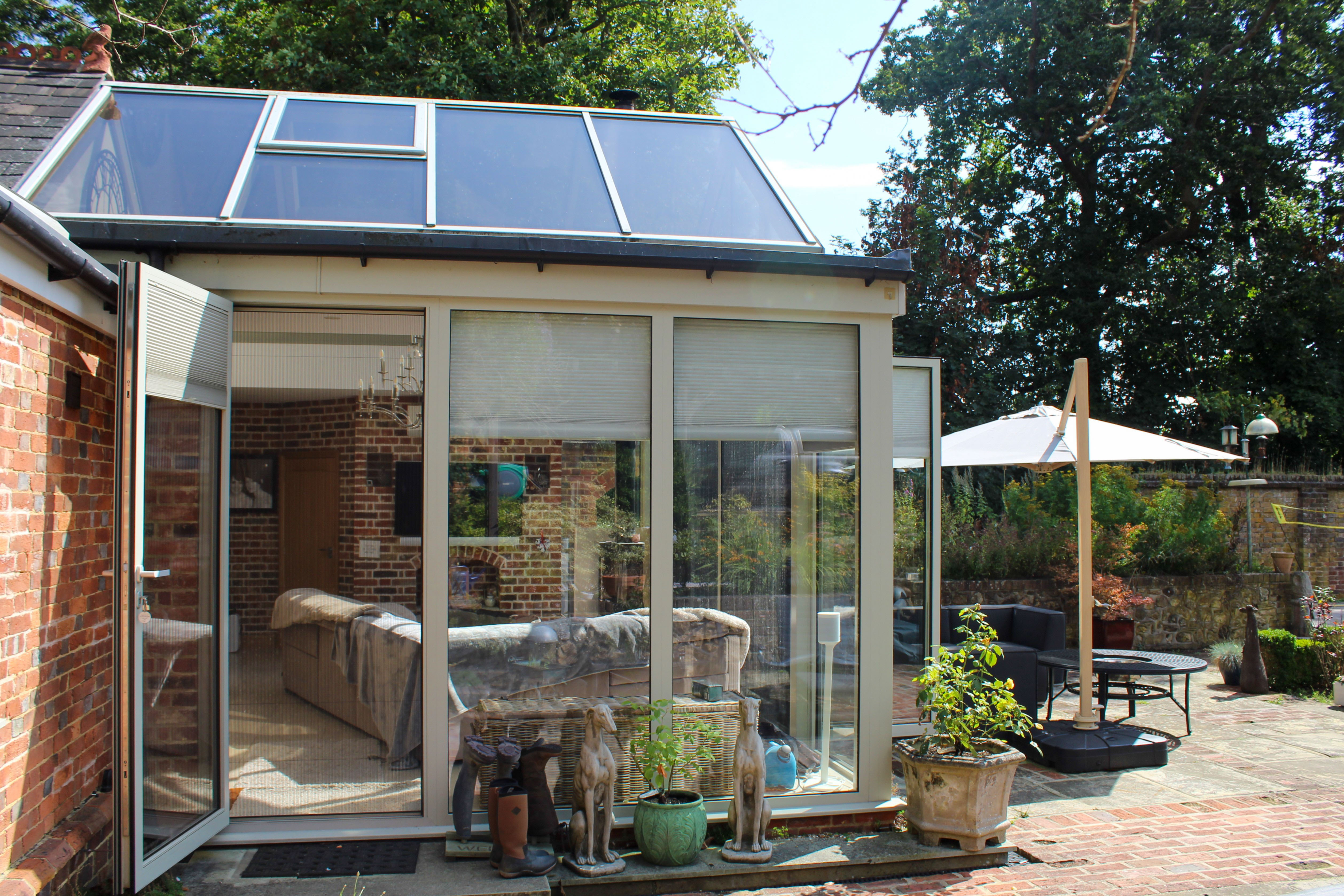 Homeowners enjoying insect-free ventilation in the conservatory with pleated door screens open