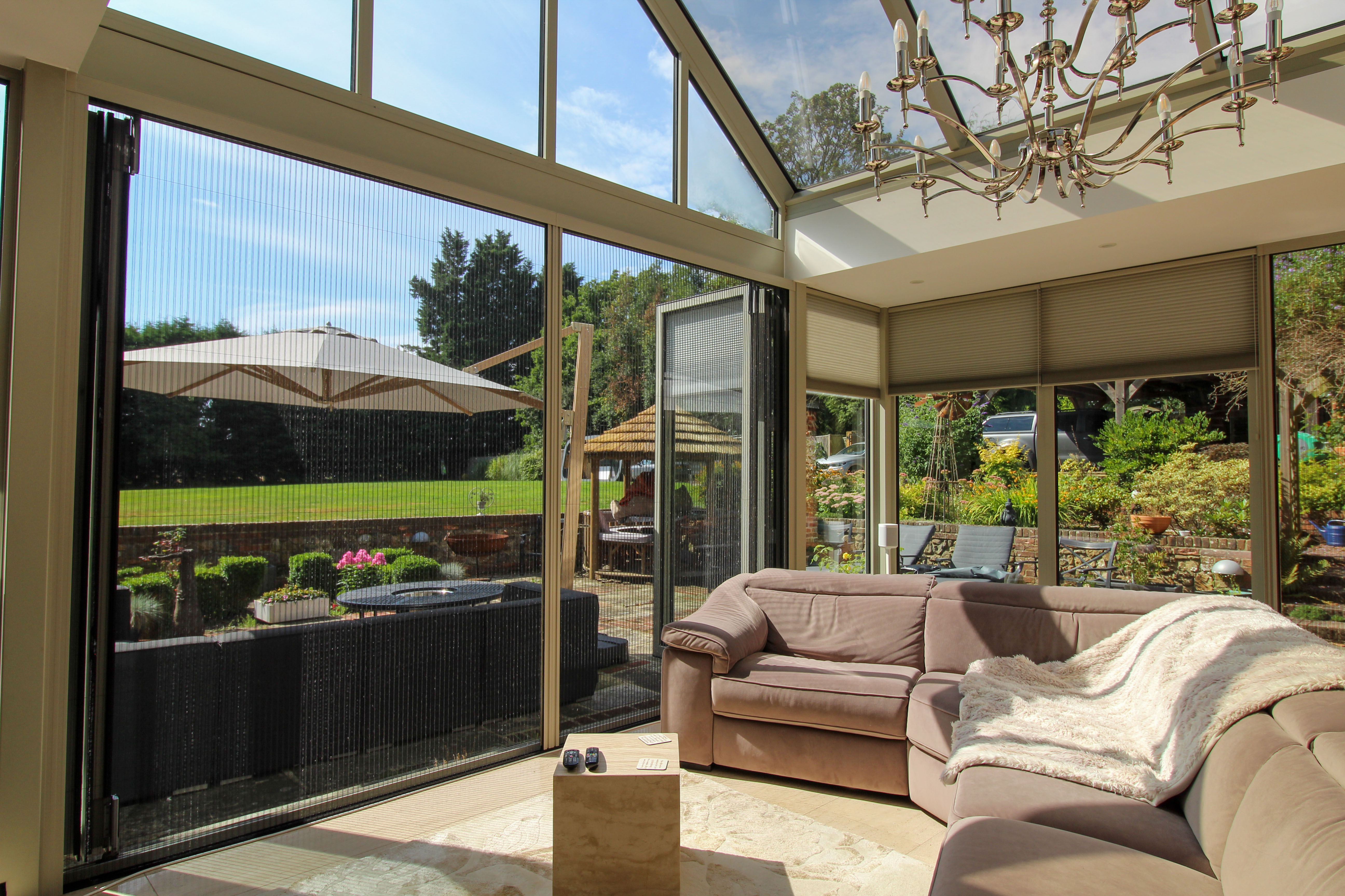 Pebble Grey pleated screen fitted to bifold doors, complementing the conservatory’s colour scheme