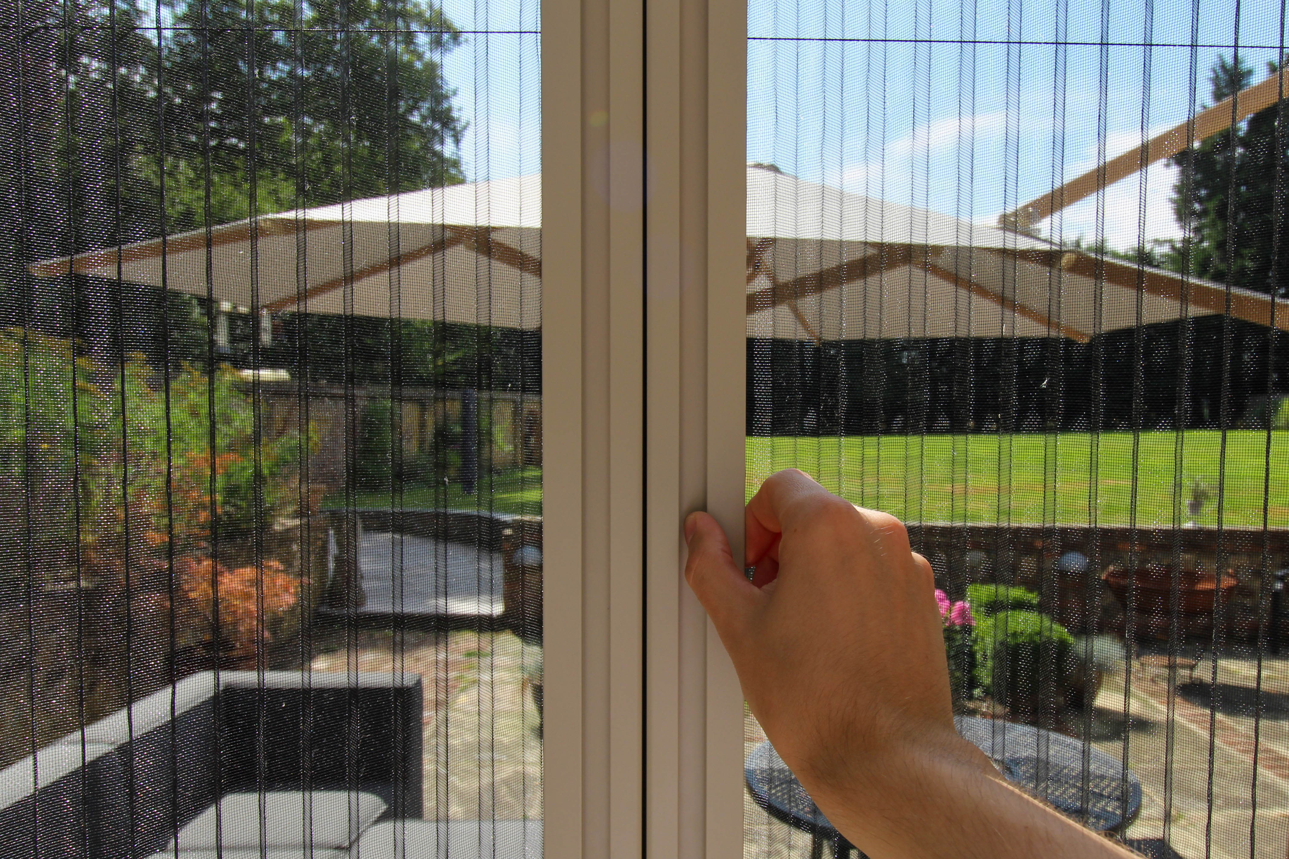 Pleated door screen fully extended, creating a barrier against insects while allowing natural airflow