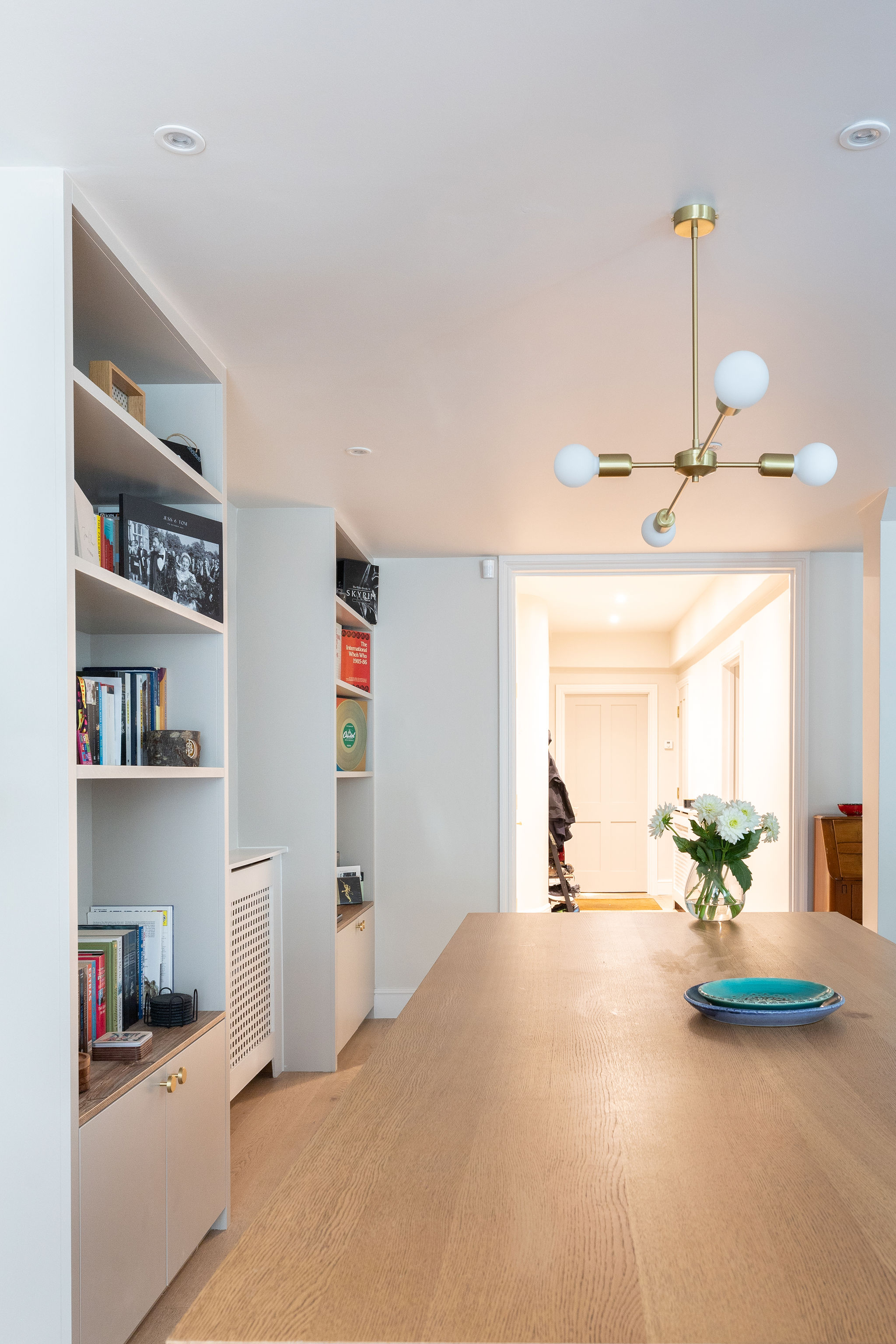 Light blue walls with bespoke joinery, large wooden table and modern pendant