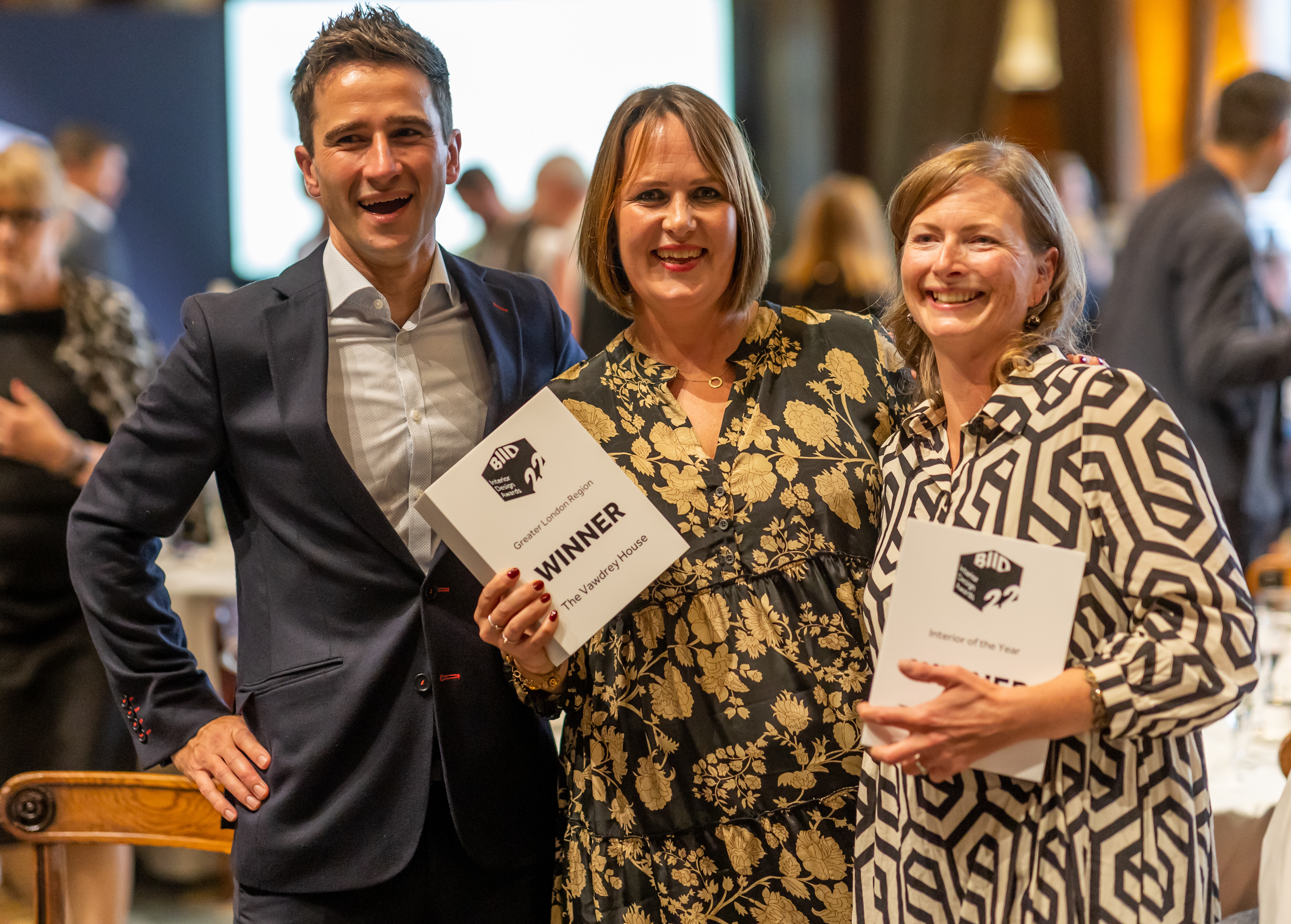 three smiling winners with awards