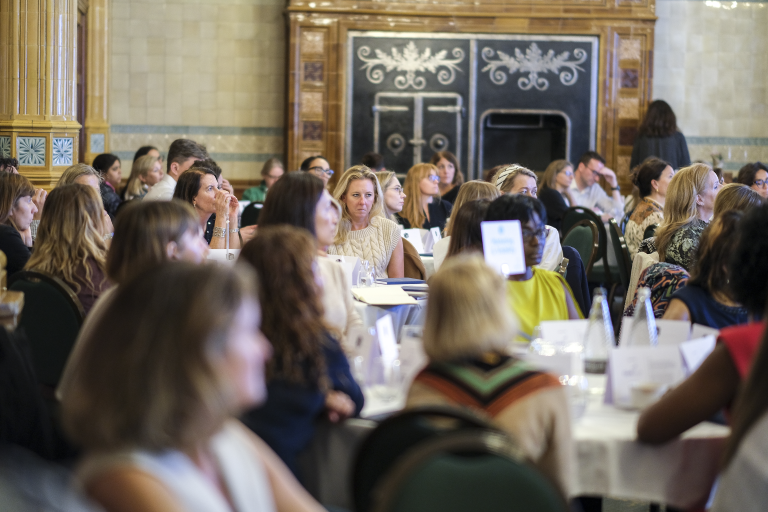 A room full of people sitting at tables