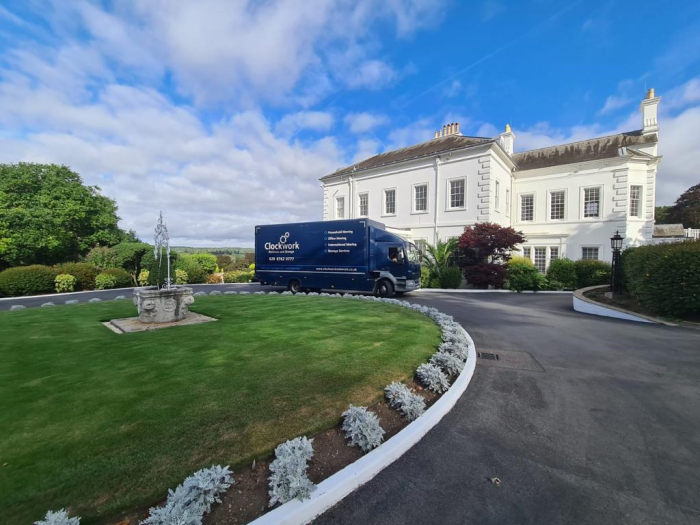 removals van outside a big white house.