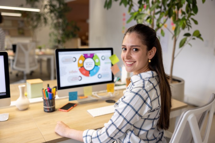 woman at her desk looking over her shoulder at the camera