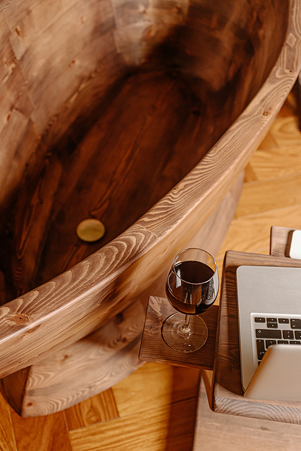 Close-up view inside the Nautilus wooden bathtub, highlighting the smooth sculpted interior and natural wood grain.