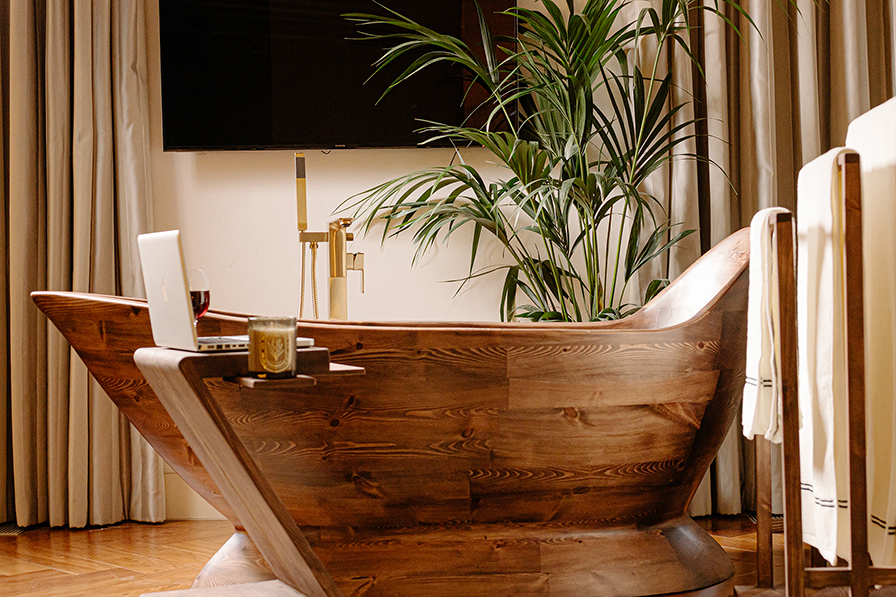 The Nautilus freestanding wooden bathtub by Dream Stuff Studio, shown in a cozy open living space as a sculptural centrepiece
