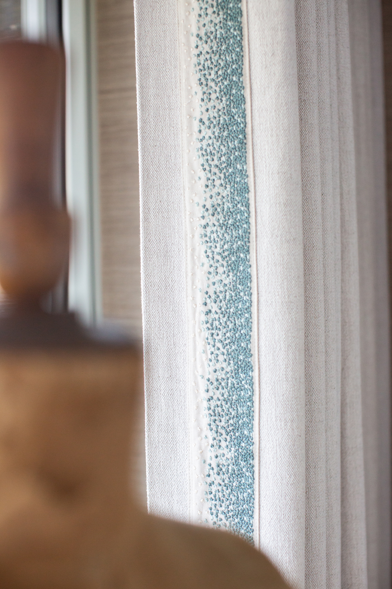Close-up of tailored curtain detailing within a contemporary riverside new build, highlighting the refined material choices and attention to detail typical of luxury interior architecture and high-end residential design.