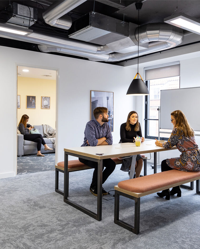 Meeting space with people talking sat at table