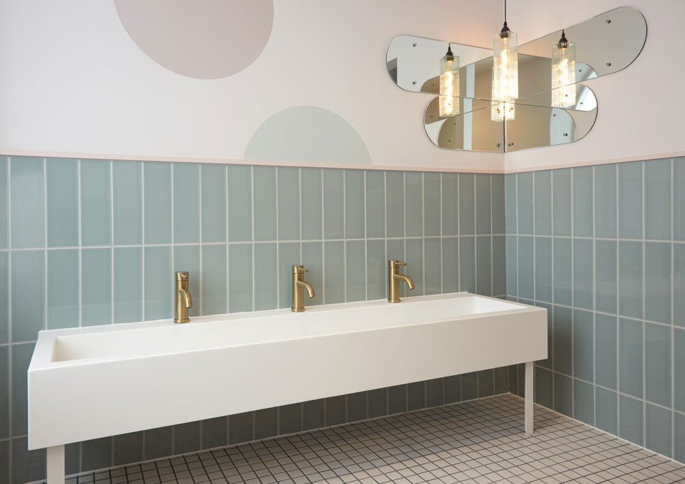 Low sink unit  with green tiled wall