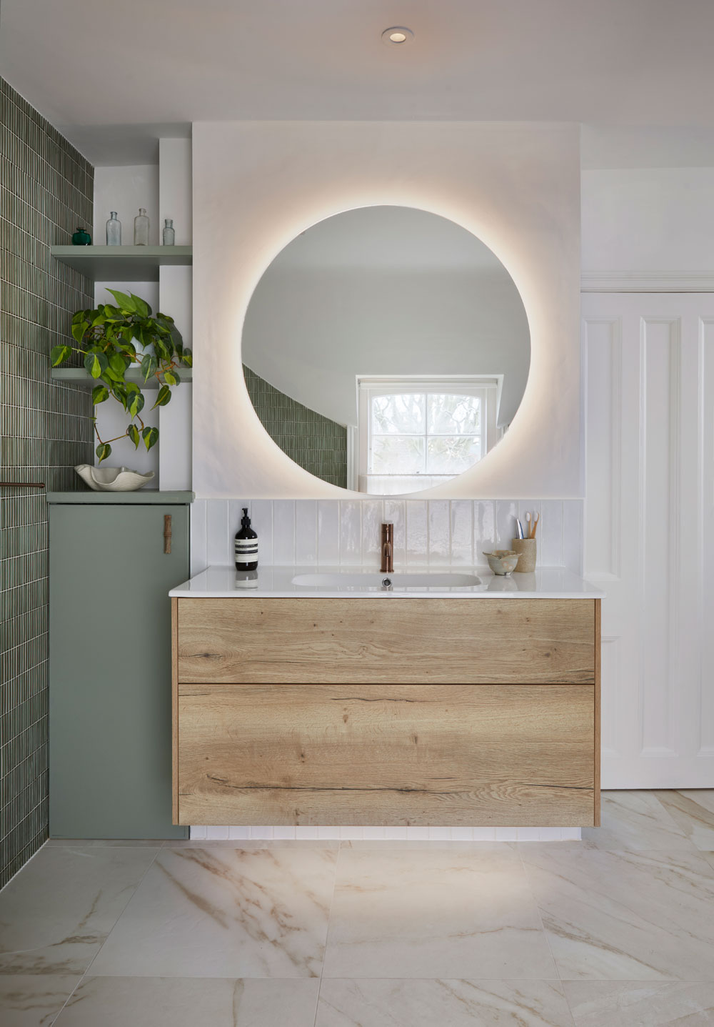 Large circular mirror above a chest of drawers