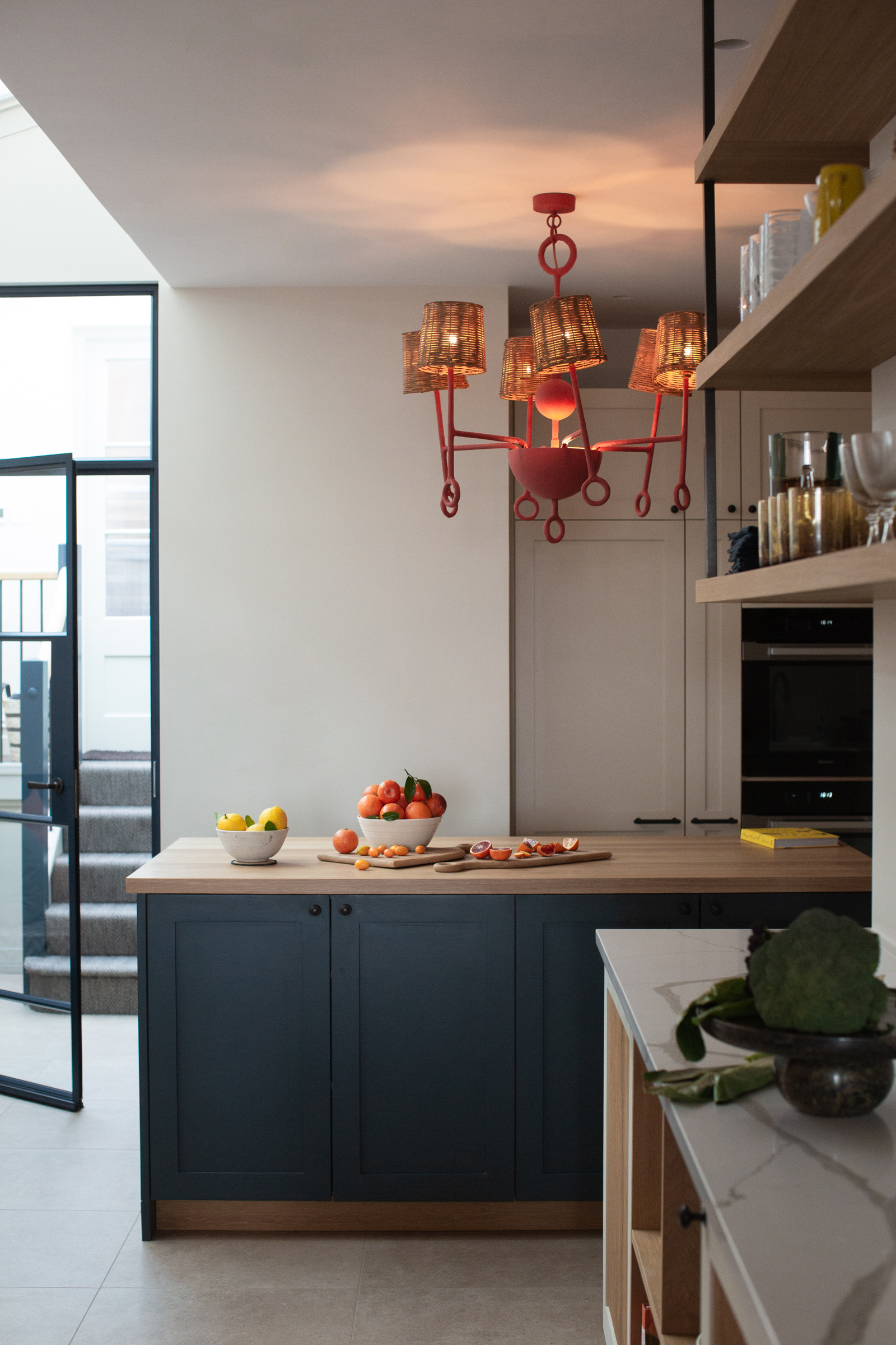 Kitchen island in a Victorian townhouse renovation, combining bespoke cabinetry, natural materials and statement lighting to create a warm, family-friendly interior.
