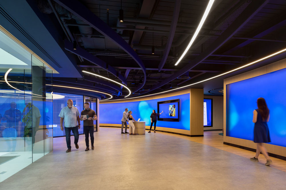 People walking past large screens