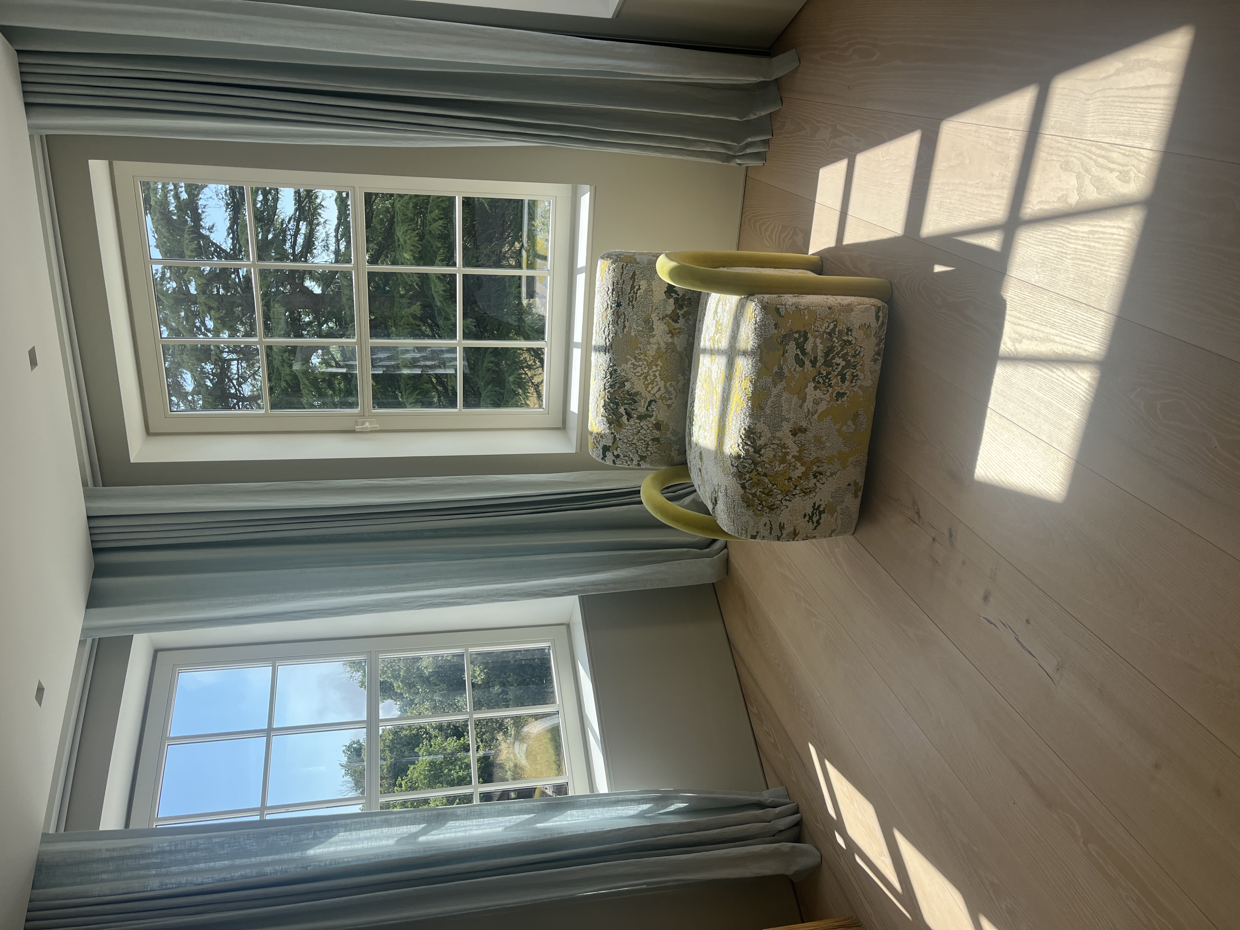 The light stream into this inviting reading space, with wall to wall ash floor boards and linen curtains in the bay
