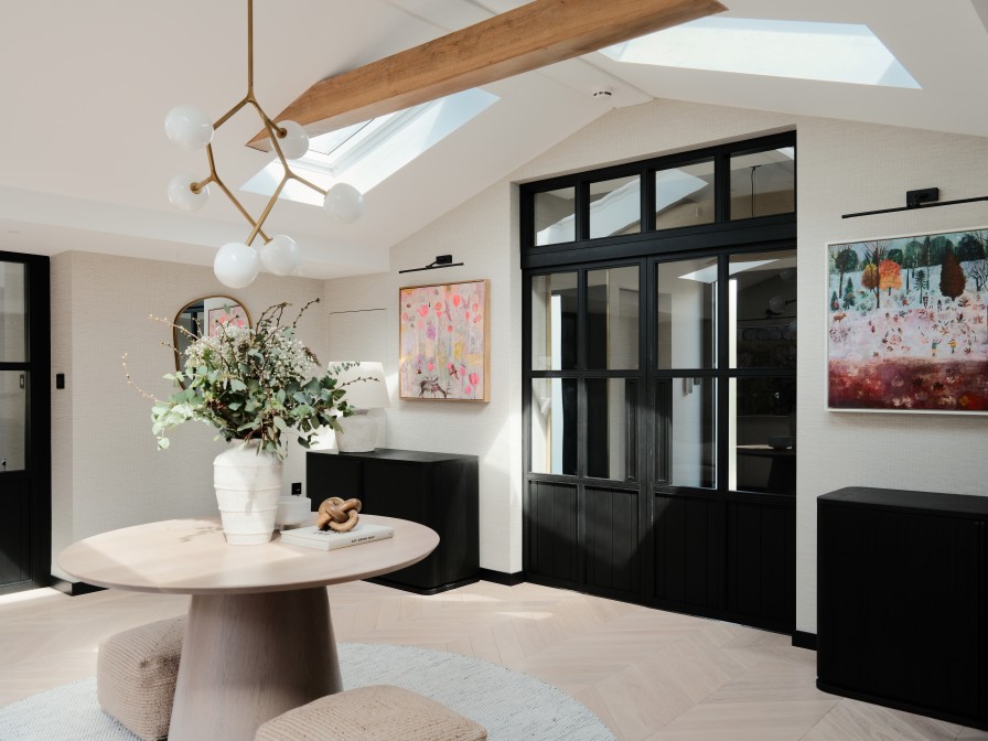 Entrance with black Crital style doors, central table with hanging pendant light.