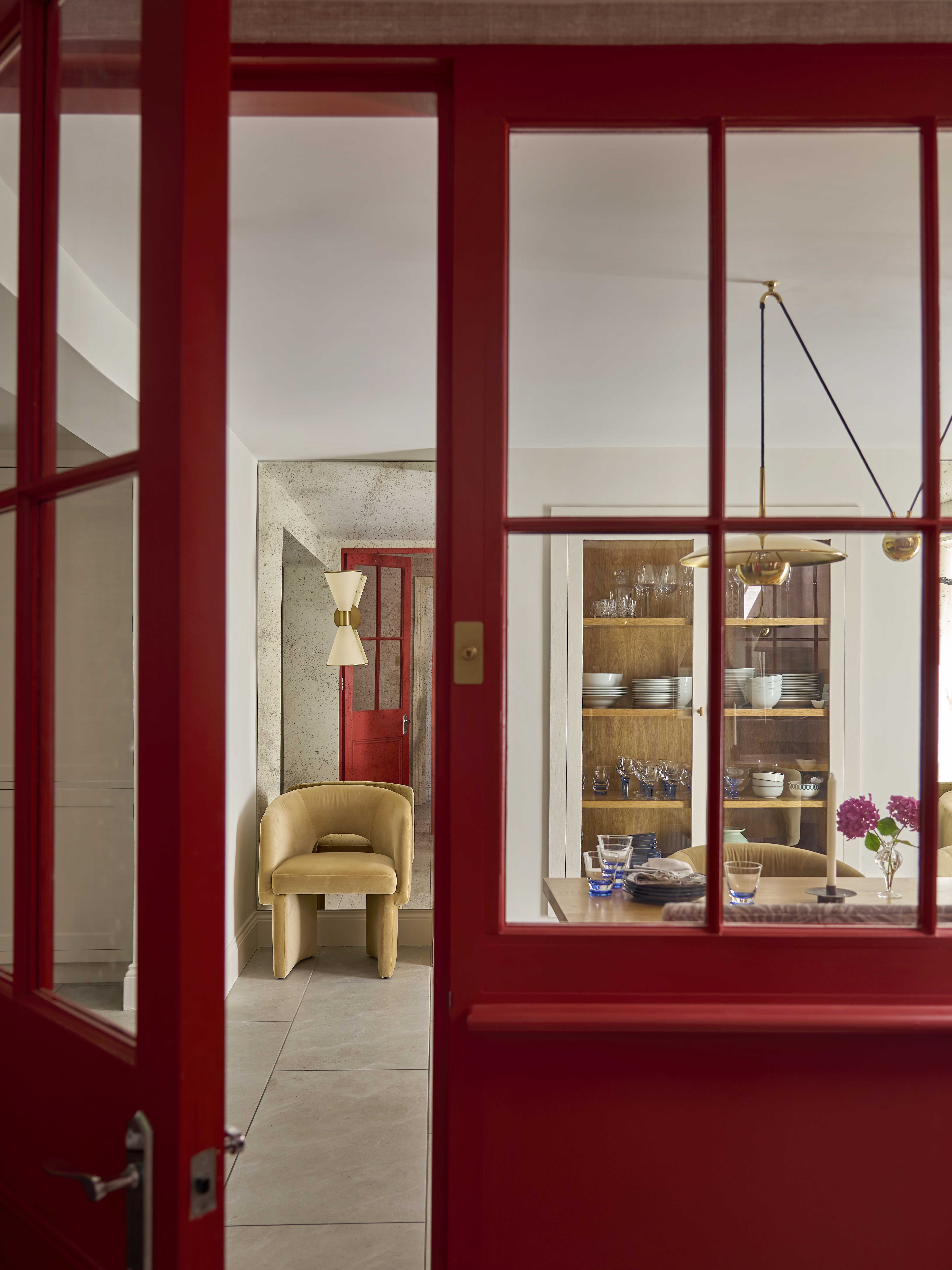 A view into the lower ground floor dining area with vibrant red accent wall.