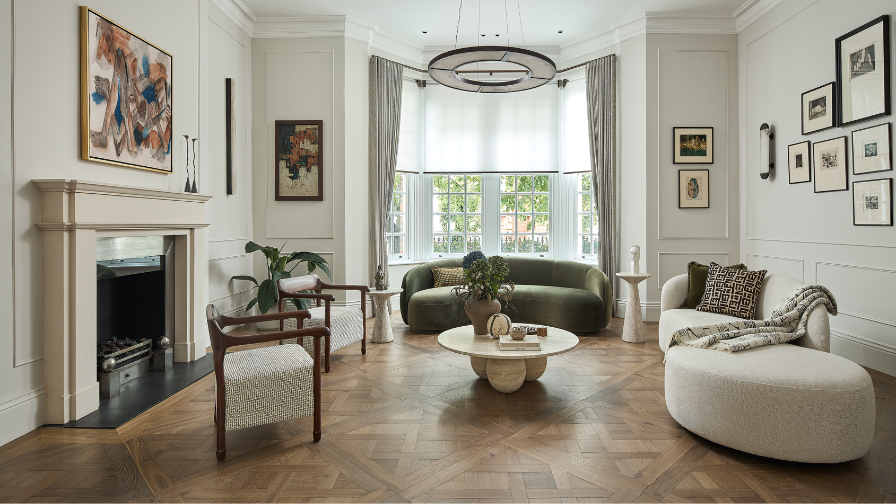 Reeception room in a victorian villa with Versailles panel parquet, white walls and velvet  curved sofas.