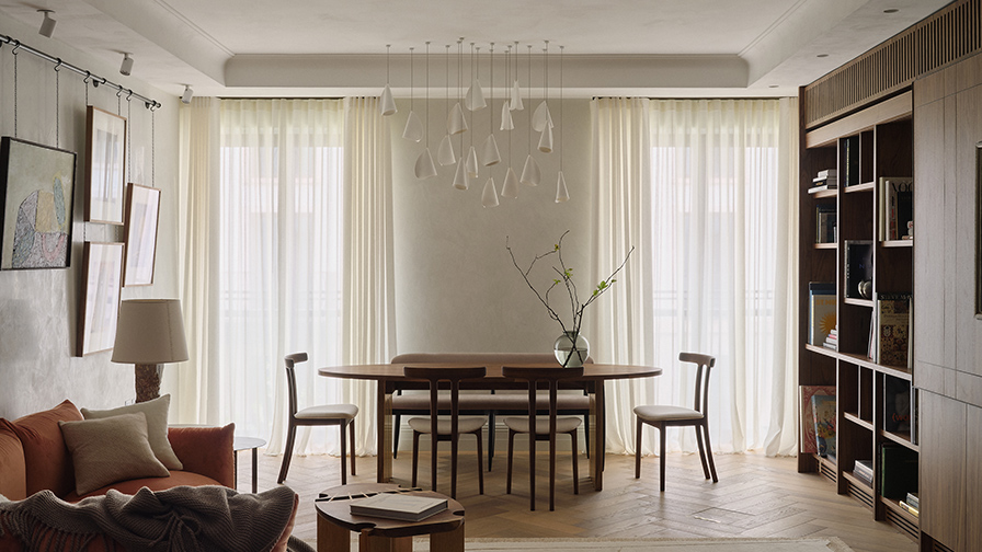 Living and dining space at Chelsea Barracks featuring floor-to-ceiling sheer curtains on concealed tracks, softly filtering daylight and complementing the apartment's warm, contemporary interior.