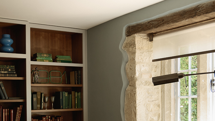 Close-up of a VENESTRE V01 roller blind with antique bronze hardware, installed within an original stone window surround in a restored Cotswolds farmhouse.