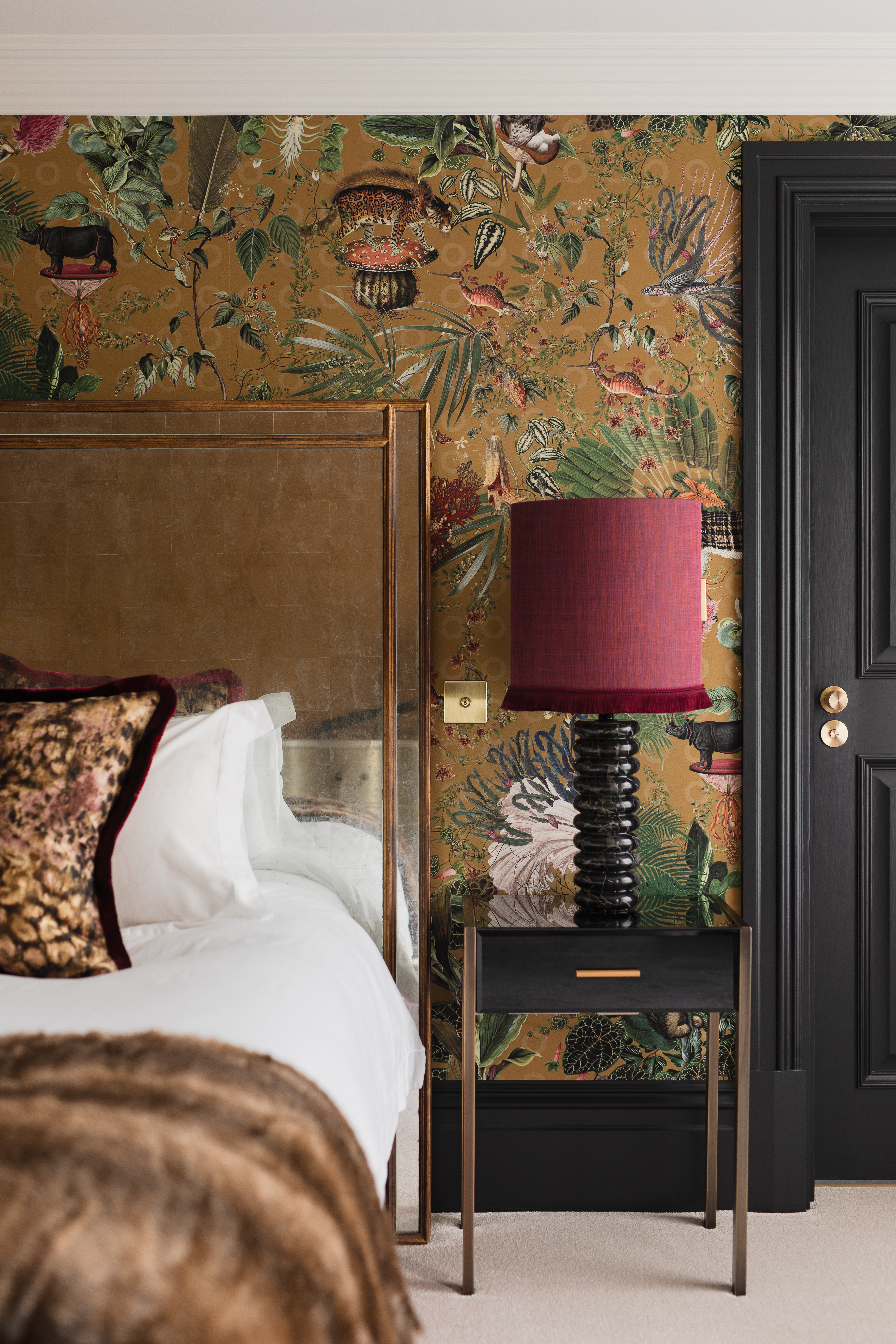 Bright colours and extinct animals on wallpaper from Moooi with black woodwork