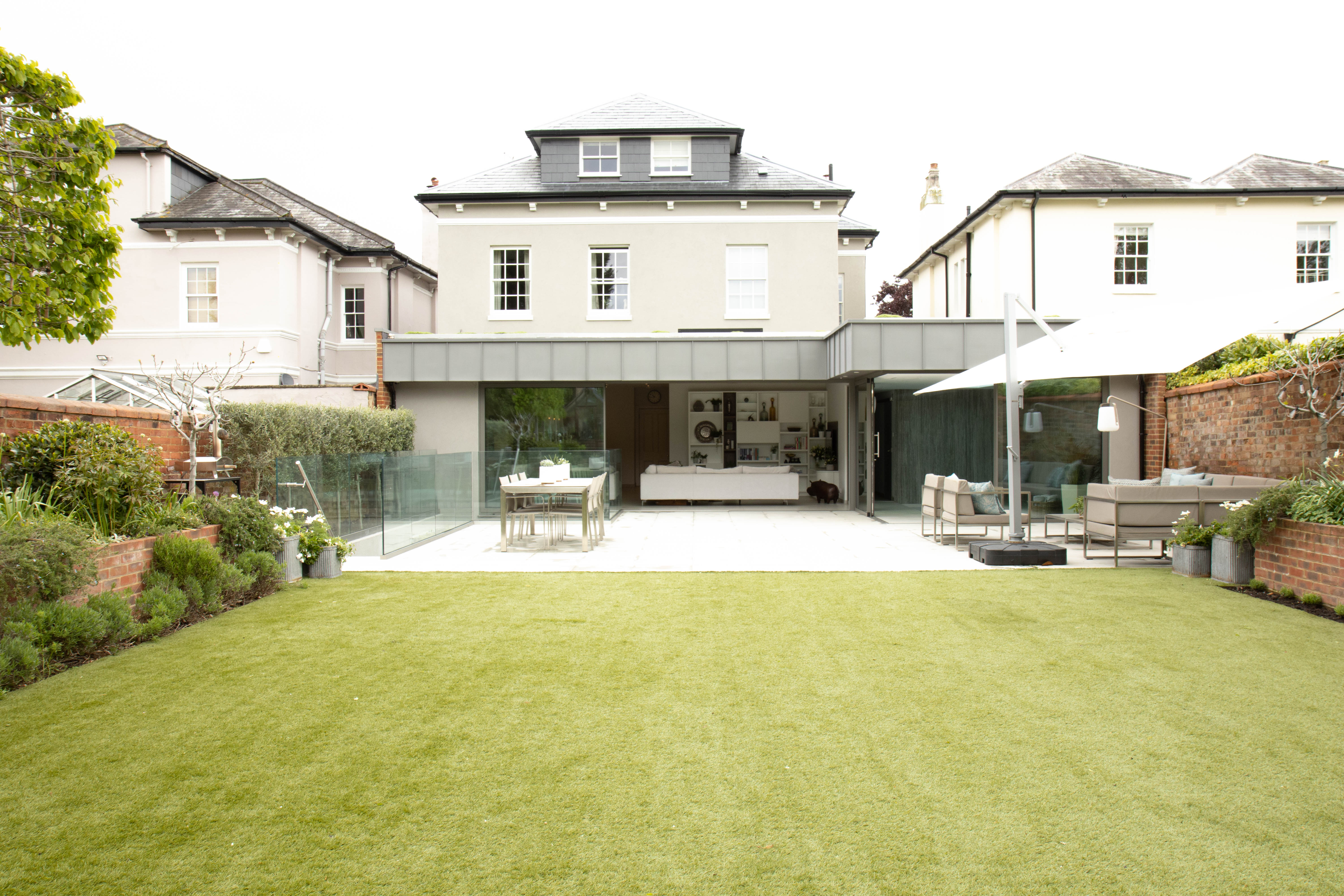 The rear view of extended Victorian house taken from the end of the garden showing roof, rear and side extensions to the finished property