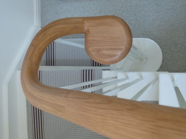Detail of curved oak handrail and painted balusters with Roger Oates runner beneath