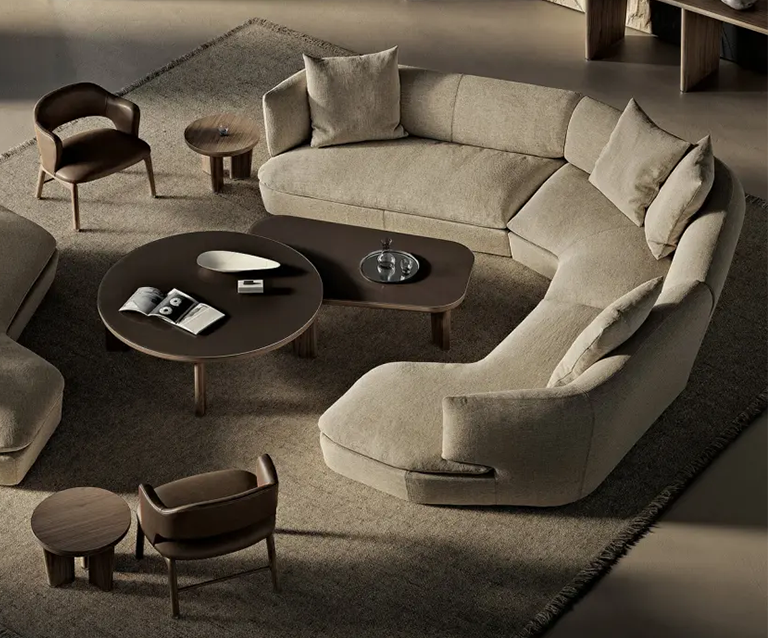 Curved cream sofa with coffee tables in front and chairs