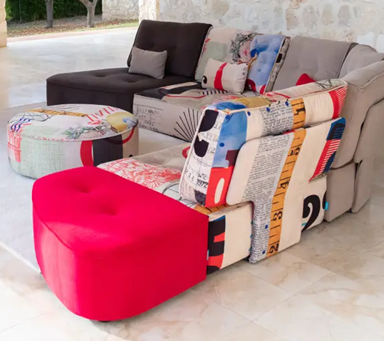 Brightly coloured corner sofa and pouffe, with red, black, grey and pattern sections