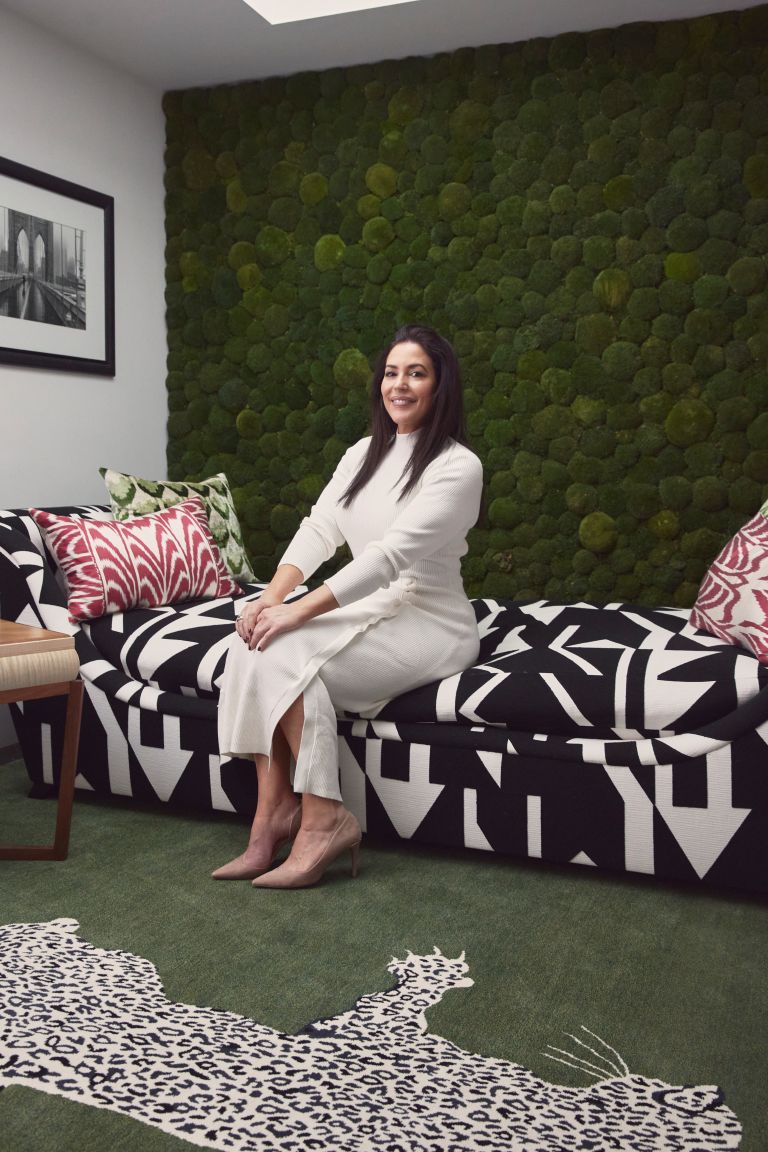 Naomi is sitting on the edge of a black and white printed bed